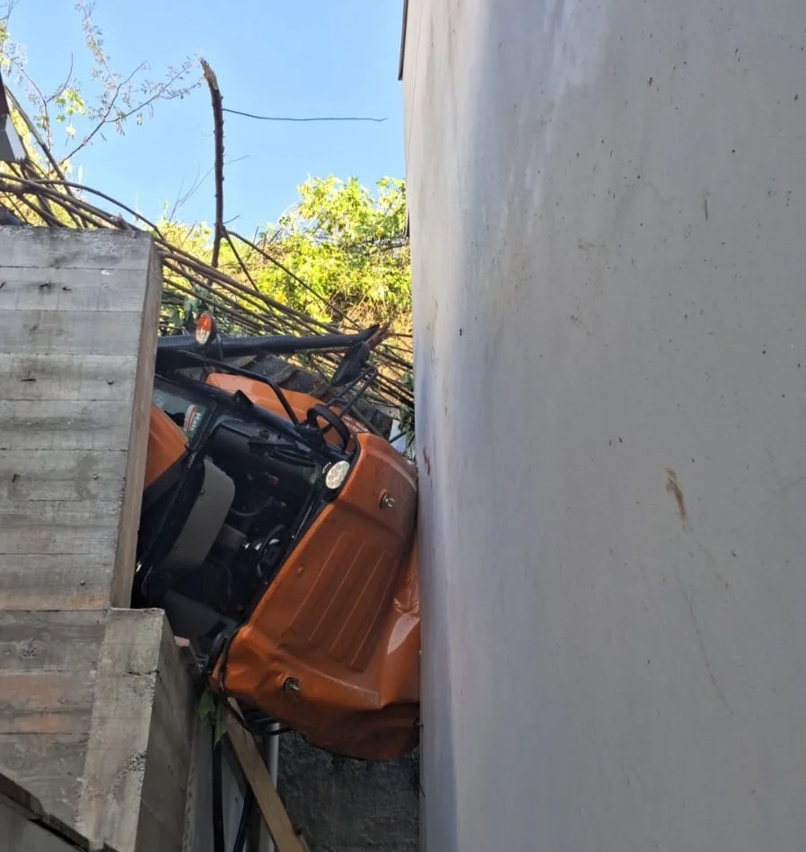 Trator desce ribanceira, atinge casa e jovem fica pendurada no veículo, em Brusque