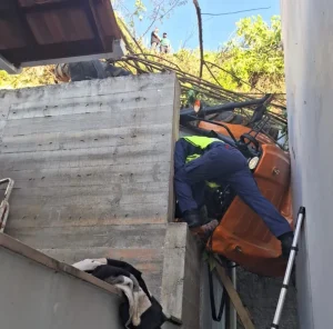 Trator desce ribanceira, atinge casa e jovem fica pendurada no veículo, em Brusque