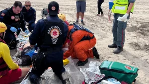 Jovem tem rosto prensado por embarcação e é socorrido de helicóptero em praia